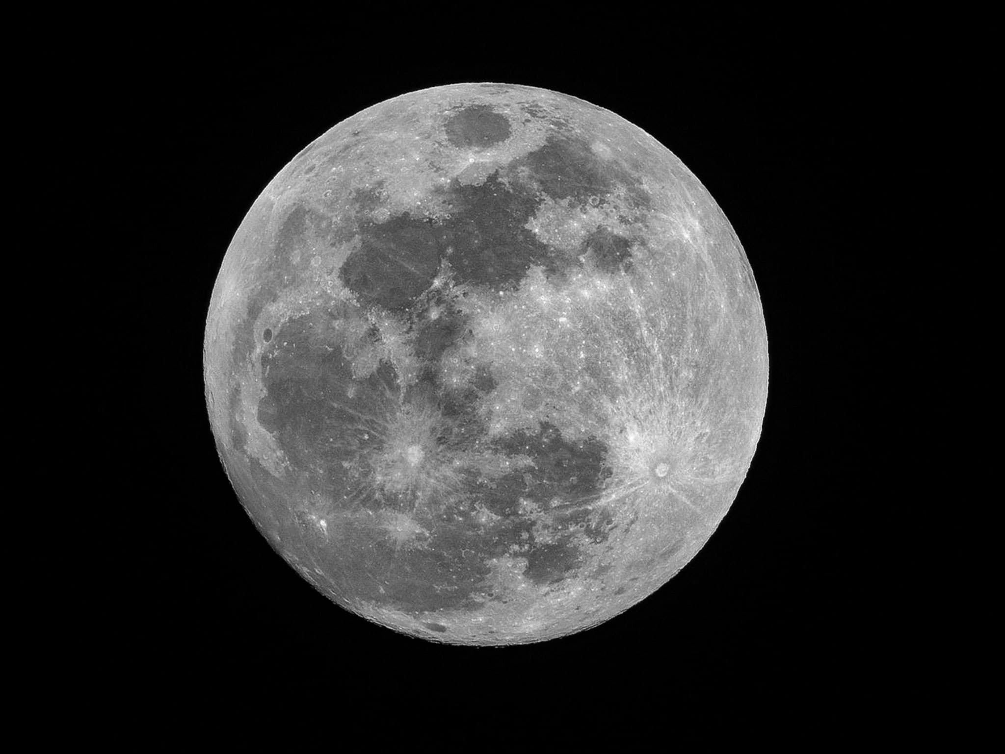 black and white photograph of the full moon showing craters and maria